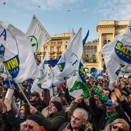 Attendees wave flags and gather during an election campaign rally for The League party at Duomo Square in Milan on Saturday, February 24, 2018. Matteo Salvini, leader of the Euro-sceptic League, said Italians must not be slaves of Berlin or Brussels and pledged to change European Union rules that hinder the country's economic growth if his party wins power in the March 4 election. Photo: Bloomberg