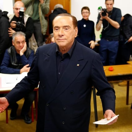 Former Italian premier Silvio Berlusconi listens to reporters at a polling station in Milan. Photo: Reuters