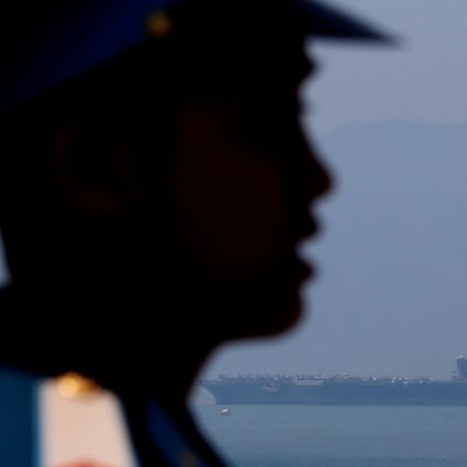 A Vietnamese soldier keeps watch as aircraft carrier USS Carl Vinson arrives at a port in Da Nang. Photo: Reuters