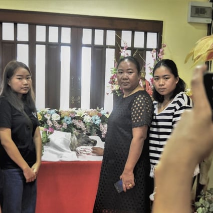 Members of the Suwan family pose for a photo with the remains of Beckham, their beloved canine companion in Bangkok, Thailand. Photo: Tibor Krausz