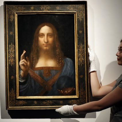 An employee poses with Leonardo da Vinci's Salvator Mundi on display at Christie's auction rooms in London. The rare painting of Christ sold for a record US$450 million last year. Photo: AP