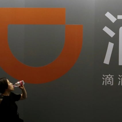 A woman walks past Didi Chuxing's booth at the Global Mobile Internet Conference in Beijing. Photo: Reuters 