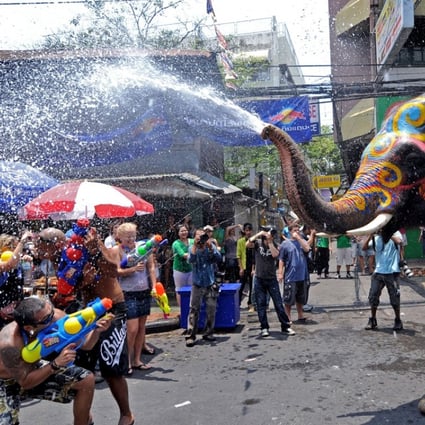 Foreign tourists spray an elephant with water guns as it spouts water during the Songkran festival to mark the Thai new year along the Khao San Road in Bangkok. Photo: AFP