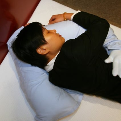 The so-called “boyfriend pillow”, targeted at lonely women, is demonstrated at a store in Causeway Bay, Hong Kong. Photo: SCMP
