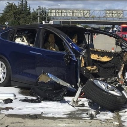 Emergency personnel work a the scene where a Tesla electric SUV crashed into a barrier. Photo: AP