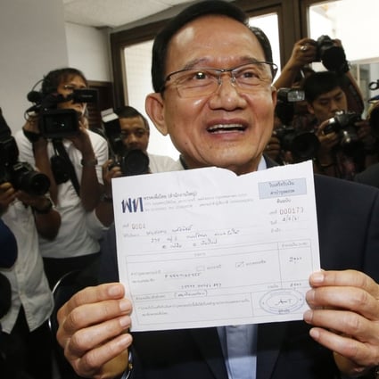 Thailand's former prime minister Somchai Wongsawat shows receipt after registering his membership to Pheu Thai Party in Bangkok. Photo: AP