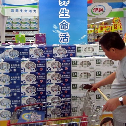 A man looks at Yili products at a store in Shanghai in this file image. The dairy company said its chairman and CEO Pan Gang was being treated for a heart condition overseas and would not be able to attend the Boao Forum for Asia as planned. Photo: Imaginechina