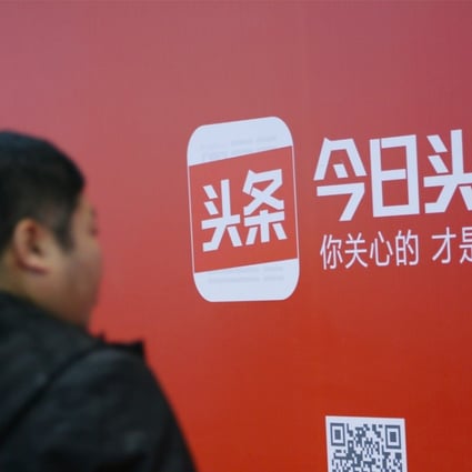 A man walks past an advertisement of Bytedance's news feed platform Toutiao, in Beijing. 