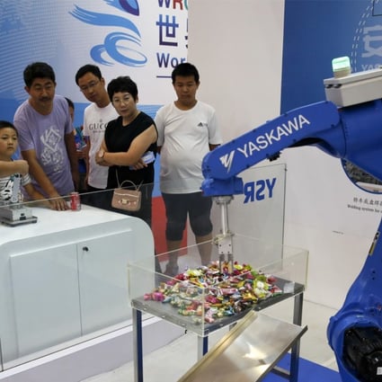 An exhibitor demonstrates a Chinese-made industrial robot to visitors at the World Robot Conference in Beijing. Photo: AP