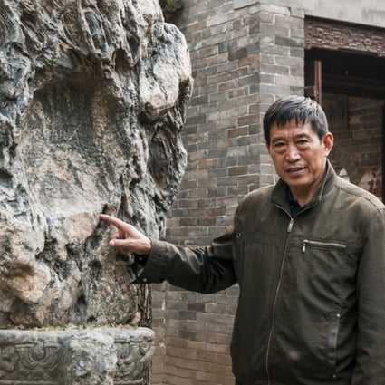 Former Red Guard Wu Jianguo with an old decorative stone, part of his collection of Chinese antiques and historical objects in rural Shaanxi province. Photo: Mark Andrews