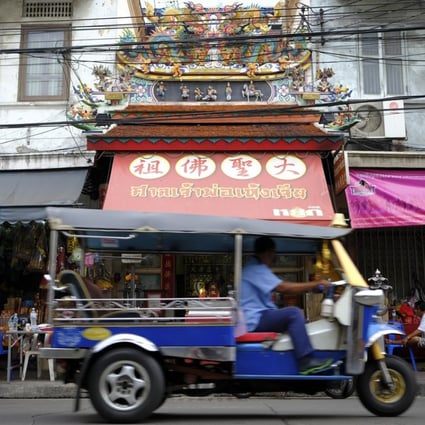 A tuk-tuk passes in front of a temple on Rama IV road in Old Chinatown, Bangkok, Thailand. Photo: James Wendlinger