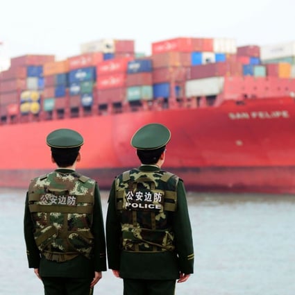 Chinese police officers watch a cargo ship at Qingdao in the eastern Shandong province. Should a full-scale trade war break out between the US and China, many countries would be forced to choose sides. Photo: AFP