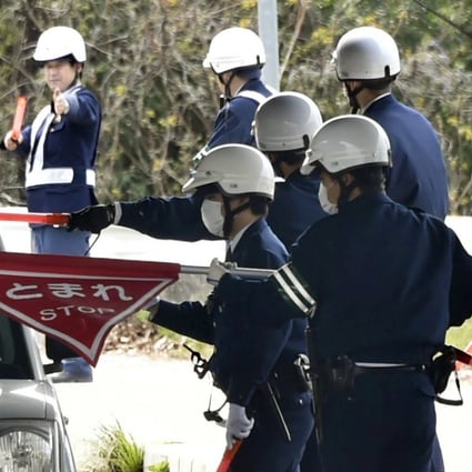 Japanese police inspect cars in Onomichi as they search for a jail breaker. Photo: AP