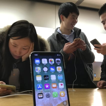 Shoppers check out the iPhone X at an Apple store in Beijing, China. Photo: AP