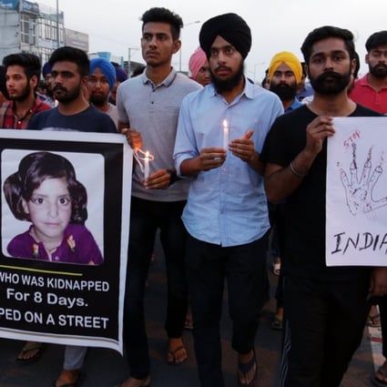Indian students hold a banner with a photo of Asifa Bano, posters and candles during a march to protest against the rape and murder of eight-year-old Asifa Bano, in Amritsar, India. Photo: EPA