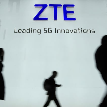 (FILES) This file picture taken on February 27, 2018 shows people walking in front of the ZTE stand at the Mobile World Congress (MWC), the world's biggest mobile fair, in Barcelona. Chinese telecom giant ZTE halted trading of its shares in Hong Kong and Shenzhen on April 17, 2018 following the announcement of a US ban on its purchase of sensitive technology that drew a pledge from China to "safeguard" its companies if necessary. / Photo: Agence France-Presse