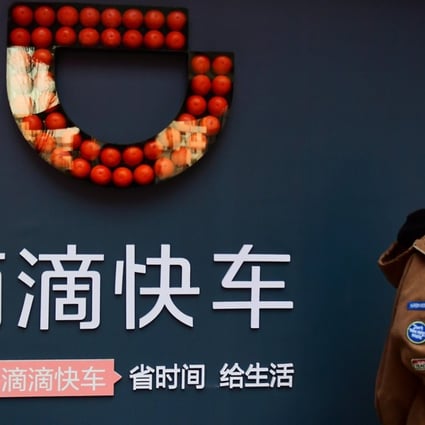 A boy walks past a sign of ride-hailing company Didi Chuxing in Shenyang, Liaoning province. Photo: Reuters
