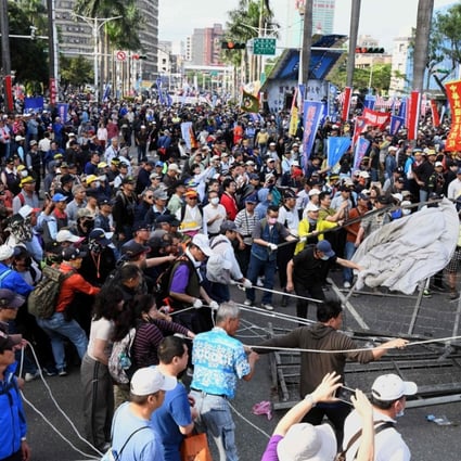 Anti-pension reform protesters pull down barricades at the entrance to parliament during a demonstration in Taipei on Wednesday. Photo: Agence France-Presse