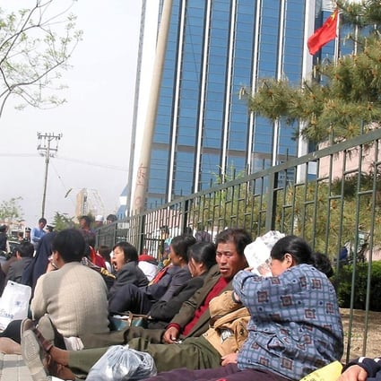 A group of Chinese farmers stage a sit-in protest outside the headquarters of the Beijing People's Congress, in Beijing, demanding compensation for land the government repossessed for development. Picture: AFP