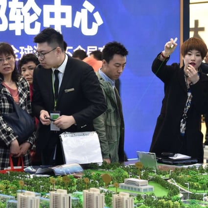 Sales staff and potential buyers at a property fair in China. Developers are less optimistic about sales growth this year as government curbs and higher mortgage rates bite. Photo: Reuters