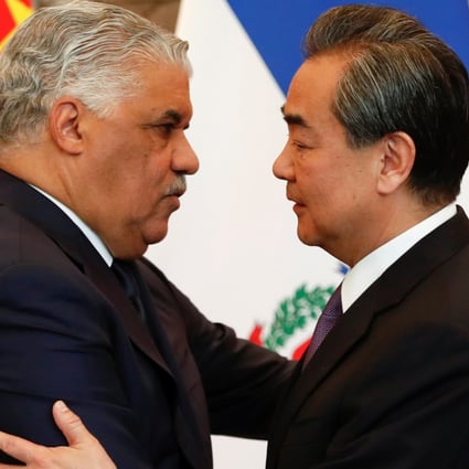 China's State Councillor and Foreign Minister Wang Yi (right) hugs the Dominican Republic's Chancellor Miguel Vargas during a signing ceremony in Beijing. Photo: Reuters