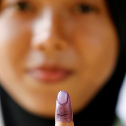 A Malaysian military officer shows her finger marked with indelible ink after casting her ballot during the early voting at Kementah Camp in Kuala Lumpur. Photo: Reuters