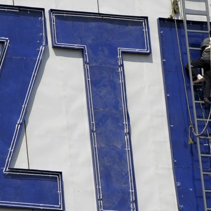 A worker installs a ZTE logo onto a building in Nanjing in eastern China's Jiangsu province in April 2001. ZTE has ceased many major operations after it was hit with a US ban stopping sales of parts to the company, a source told the ‘South China Morning Post’. Photo: Chinatopix Via AP
