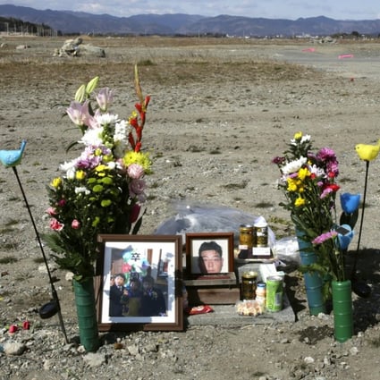Flowers and photos are placed where the Ukedo Post Office stood in Fukushima, Japan, before the tsunami struck the area in 2011. Photo: EPA