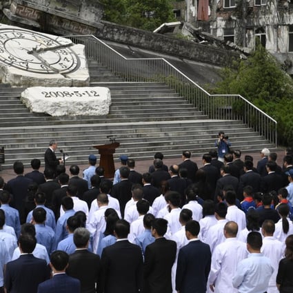 An official ceremony is held outside the Xuankou Middle School, which is now a memorial site where the hands of a broken clock are frozen at 2.28pm – the time the earthquake struck. Photo: Xinhua