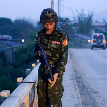 A militiaman linked to the Malaysian army stands on a bridge in Muse. China on Sunday condemned fighting on its border between Myanmar forces and ethnic rebels that left 19 people dead, most of them civilians. Photo: AFP