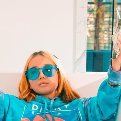 Lil Tay, lying in a bathtub, holds up wads of US$100 bills in one of the controversial videos of her posted online. Photo: courtesy of Instagram
