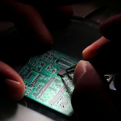 A researcher planting a semiconductor on an interface board during a research work to design and develop a semiconductor product at Tsinghua Unigroup research centre in Beijing on February 29, 2016. Photo: Reuters
