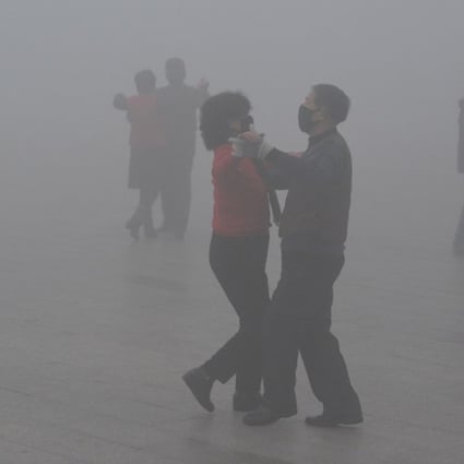 People wearing face masks dance in a square on a polluted day in the eastern China city of Fuyang. Photo: Reuters