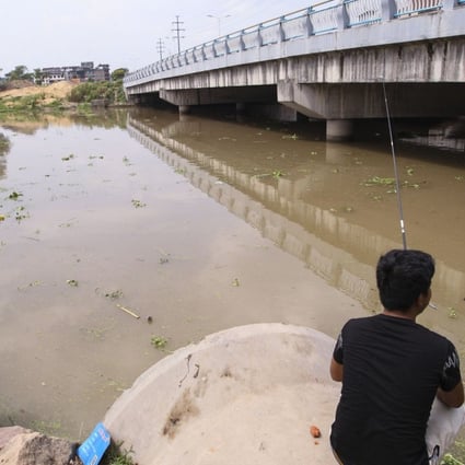 A flle picture of a man fishing in a flooded river in Yongkang in eastern Zhejiang province. Photo: Simon Song