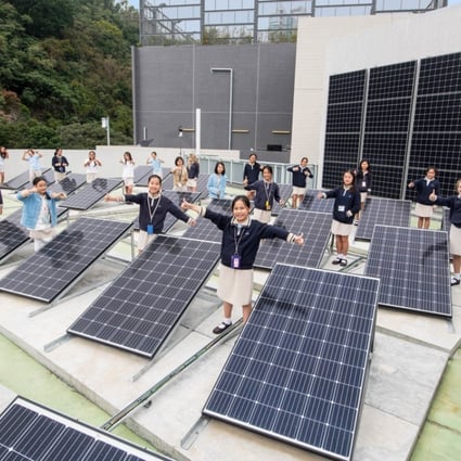 Pupils at The ISF Academy standing among the school’s rooftop solar panels. Photo: Kitmin Lee