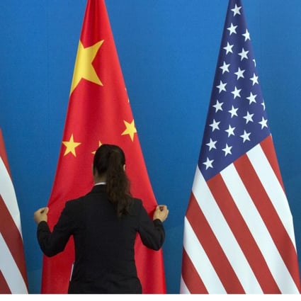 A Chinese woman adjusts a Chinese flag near US flags before a meeting between the countries in Beijing in 2014. Photo: AFP