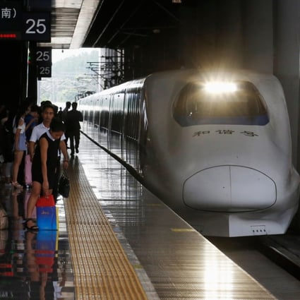 Passengers wait on the platform as a high-speed train approaches at Hangzhou East railway station in Zhejiang province, China. Photo: Bloomberg