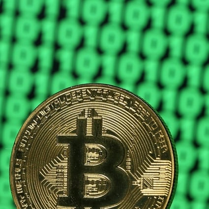 A token of the virtual currency Bitcoin is seen placed on a monitor that displays binary digits. Photo: Reuters