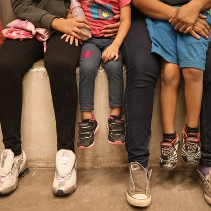 In this file photo taken in September 2014, women and children sit in a holding cell at a US Border Patrol processing centre after being detained by agents near the US-Mexico border near McAllen, Texas. A father of one killed himself after being separated from his family in McAllen in a controversial policy started by Donald Trump. Photo: AFP