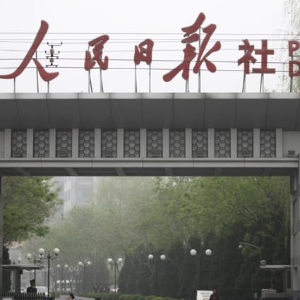 A man cycles past the main entrance of People's Daily in Beijing. Photo: Reuters