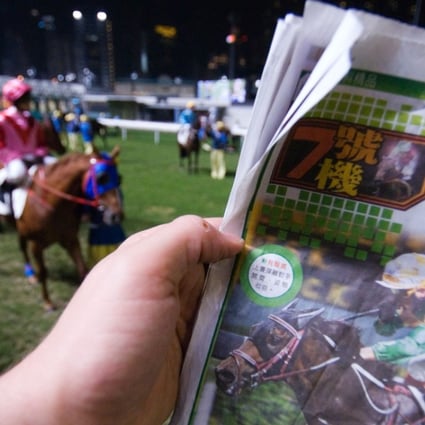 A punter checks the horse form at Happy Valley racecourse, in Hong Kong. Picture: Alamy