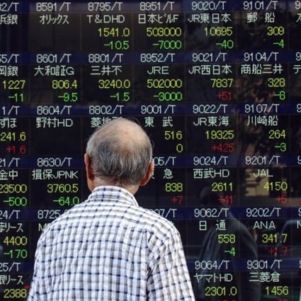 Investors watch a share prices board in Tokyo. Photo: AFP PHOTO