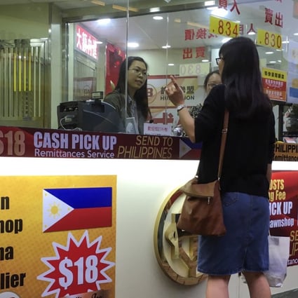A customer at Hui's Brothers Currency Exchange Group, one of the biggest remittance agents in Hong Kong, which charges a HK$18 fee for each transaction. Photo: Eugene Tang
