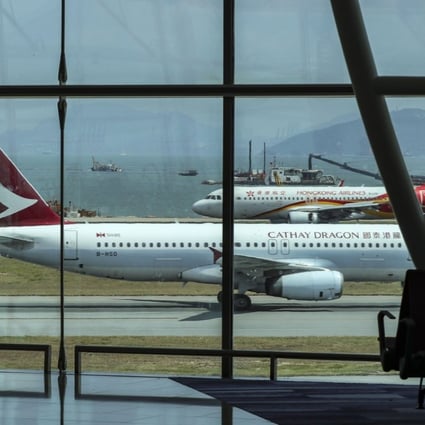 A passenger looks at aircraft at Terminal 2 of the Hong Kong International Airport in Chek Lap Kok on May 27. The city is constructing a third runway to cope with increasing air traffic, and there have been suggestions that it needs a fourth. Photo: Roy Issa