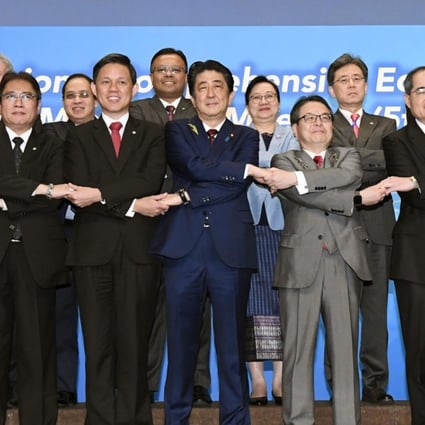 Japanese Prime Minister Shinzo Abe, centre, joins hands with trade ministers from Asian countries for a group photo during the Regional Comprehensive Economic Partnership (RCEP) meeting in Tokyo. Photo: AP