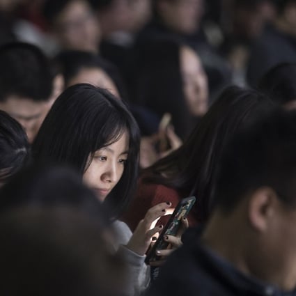 An attendee uses her smartphone during Tencent Holdings Ltd.'s WeChat Open Class Pro conference in Guangzhou, China, on Monday, Jan. 15, 2018. WeChat, the social network that is nearly ubiquitous in China, said at the conference that it has 580,000 mini-programs in operation. Photographer: Qilai Shen/Bloomberg
