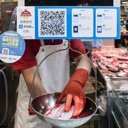 Payment instructions for Alipay at a fish stall inside a market in Hong Kong. Online payment providers face resistance in Hong Kong as customers prefer more traditional methods. Photo: Bloomberg