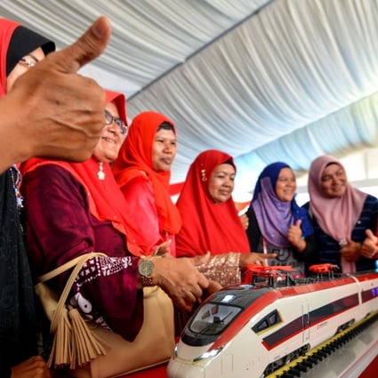 Women look at a model of a train designed to run on Malaysia’s East Coast Rail Link in this file image. The owner of the US$20 billion project has told its main Chinese contractor to suspend work on it. Photo: Xinhua