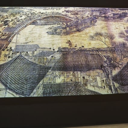 Visitors watch an interactive digital display of a masterpiece, the scroll painting Along the River During the Qingming Festival by 12th-century painter Zhang Zeduan at the Palace Museum in Beijing, China, on July 05, 2018. The painting, now housed in the Palace Museum, gives a panoramic portrayal of flourishing urban life in Bianliang (today's Kaifeng, Henan province), the capital during the Northern Song period (960-1127). Visitors can experience a moment of life in Song dynasty during this interactive show. 05JUL18 SCMP/Simon Song