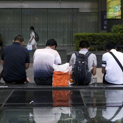Customers sit in front of a KFC restaurant near the Luohu Commercial City mall in Shenzhen. Photo: Bloomberg